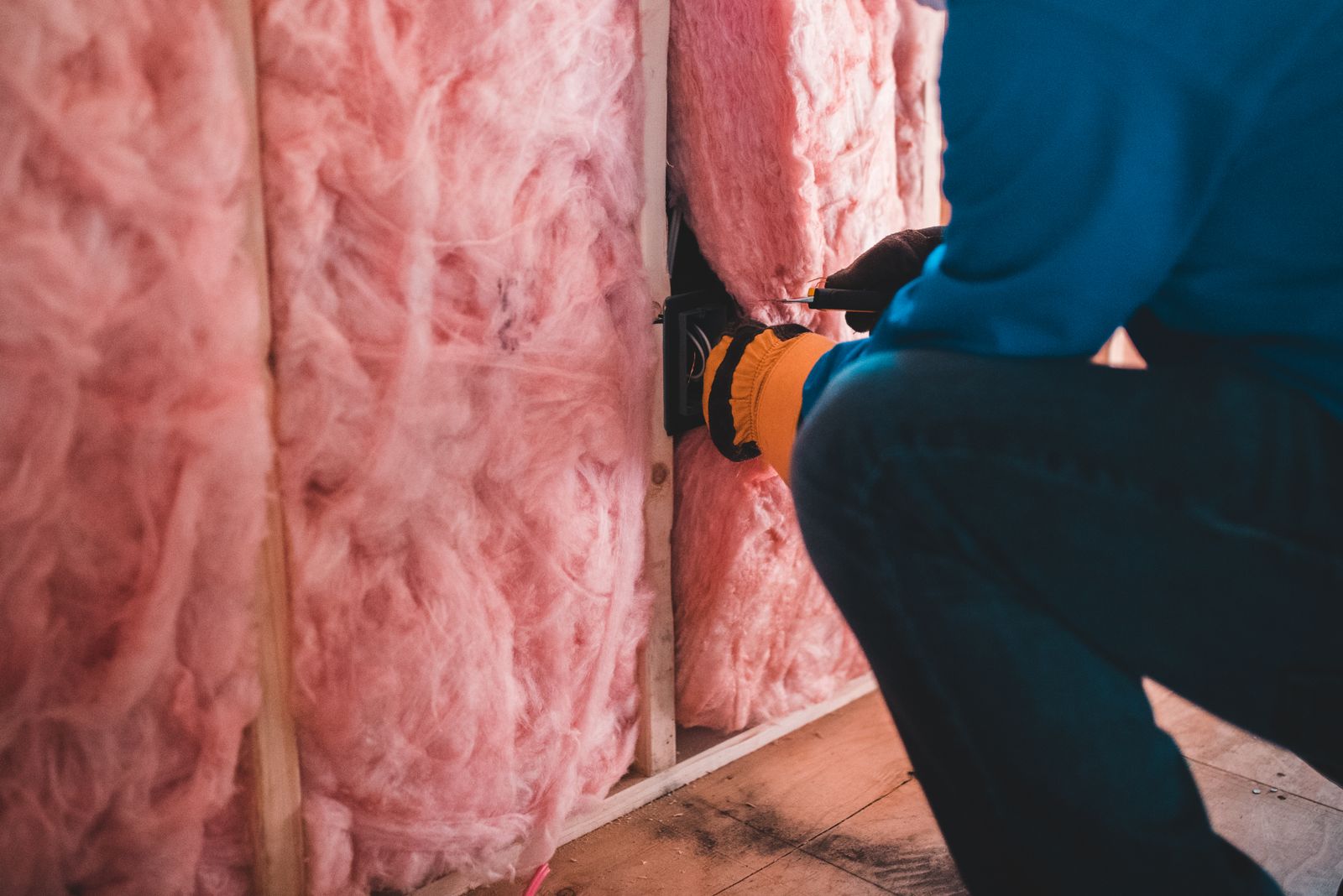 Handwerker beim Anbringen einer Wärmedämmung an der Außenwand eines Wohngebäudes