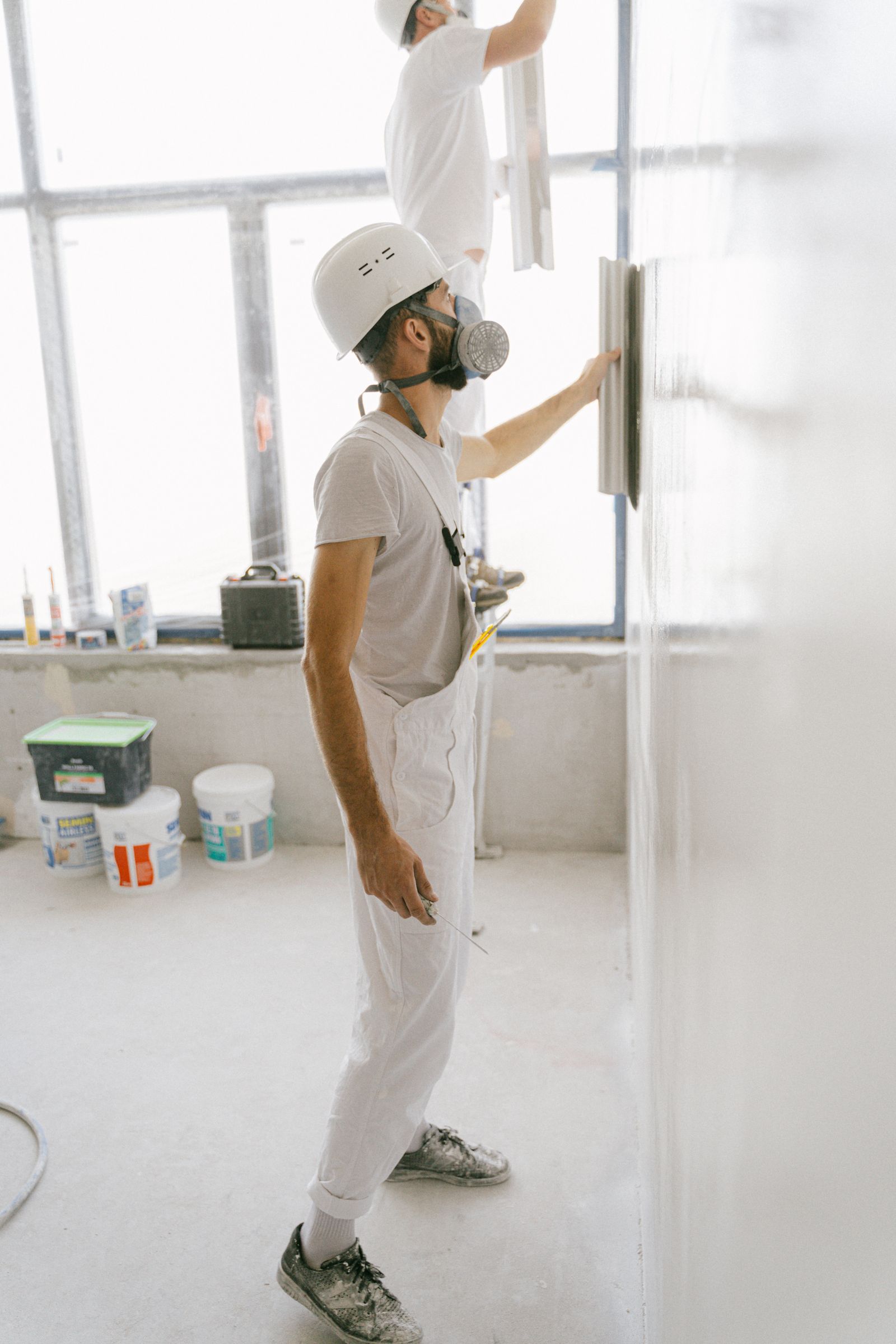 Handwerker bei der Renovierung eines Wohngebäudes als Beispiel für die Zusammenarbeit verschiedener Gewerke bei einer energetischen Sanierung