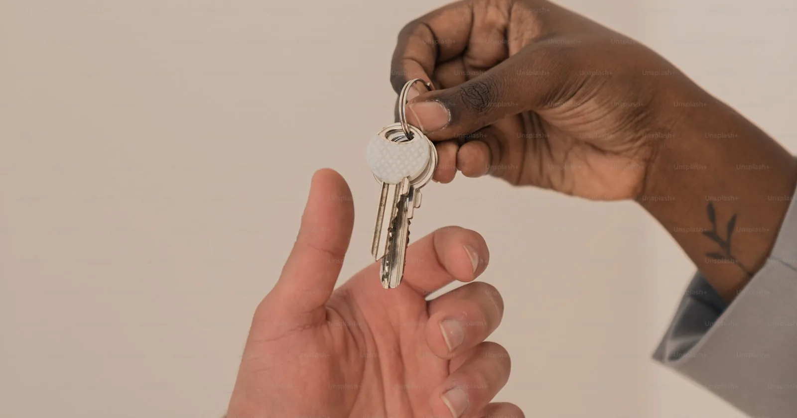 Schlüsselübergabe bei Immobilientransaktion, symbolisch für die Bestandsübergabe einer Hausverwaltung