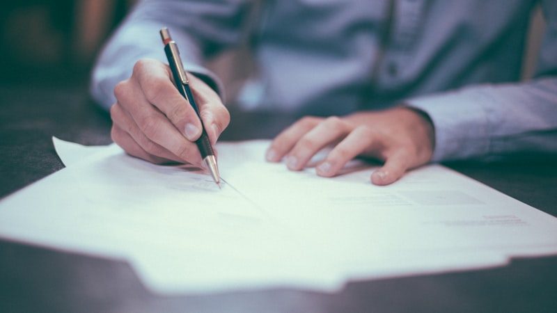 Person am Schreibtisch prüft Unterlagen und Abrechnungsbelege