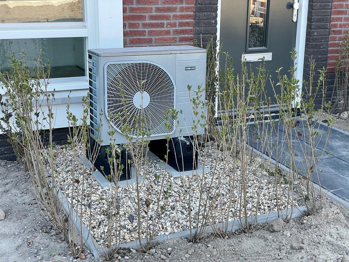 Wärmepumpe vor einem Wohngebäude – moderne Heiztechnik als Alternative zu fossilen Heizungen